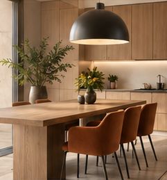 Warm timber interior with a dining table and orange upholstered chairs.